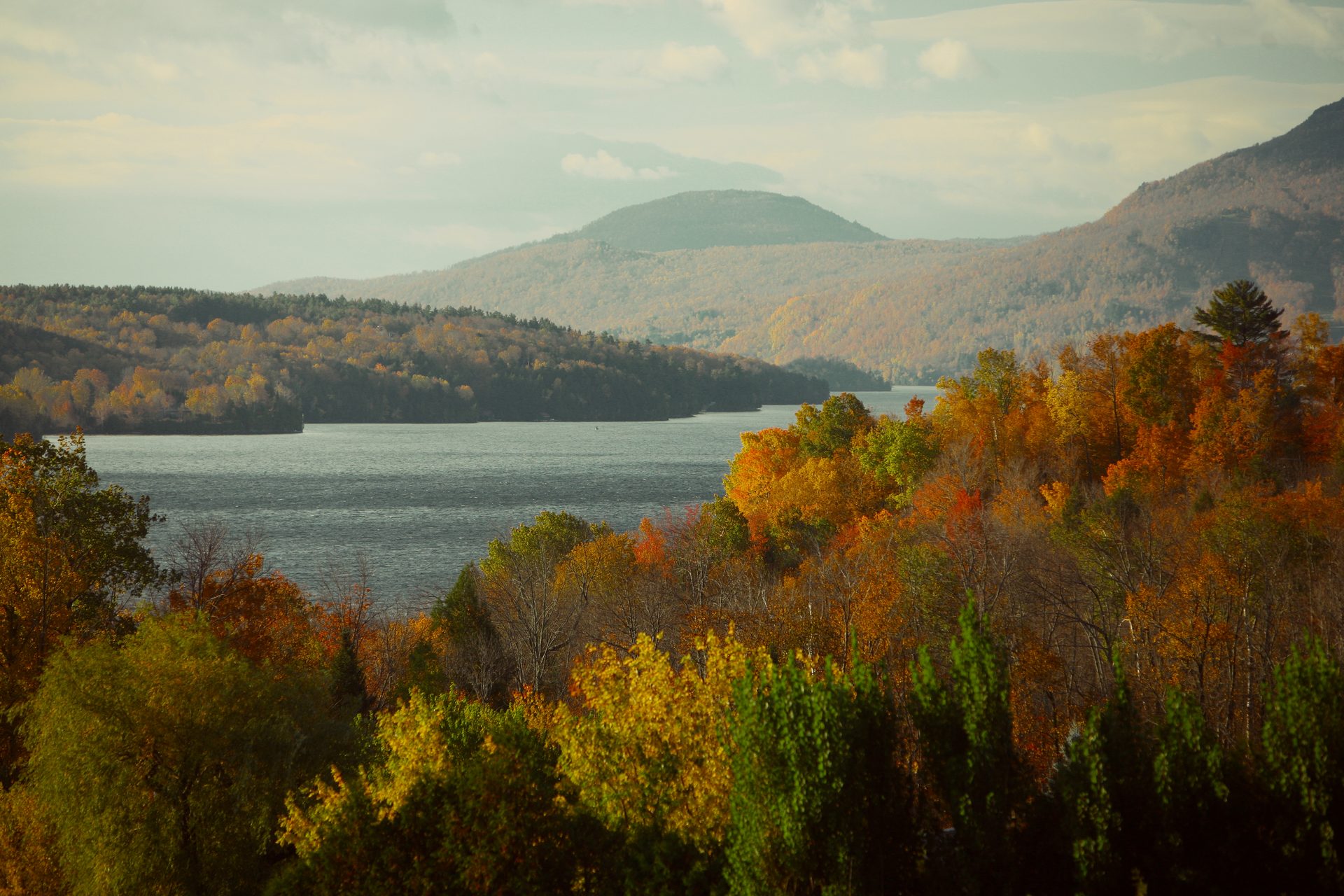 A forest and lake reflecting the surrounding trees, evoking the Isha Upanishad's teaching of seeing the self in all things